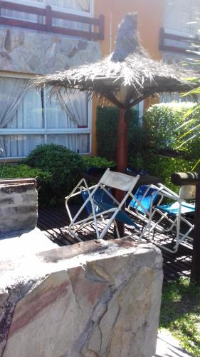 two chairs and an umbrella in front of a building at Paraiso Colon in Colón