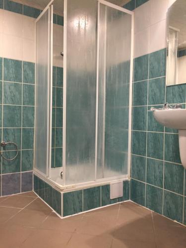 ブルノにあるApartmán v dobré lokalitěの緑のタイル張りのバスルーム(シャワー付)