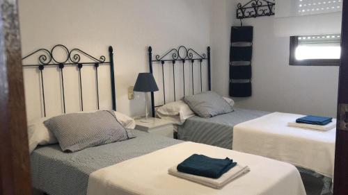 a room with two beds with towels on them at PISO EN PLAZA DE ESPAÑA Y PLAYA DE LA COLONIA in Águilas