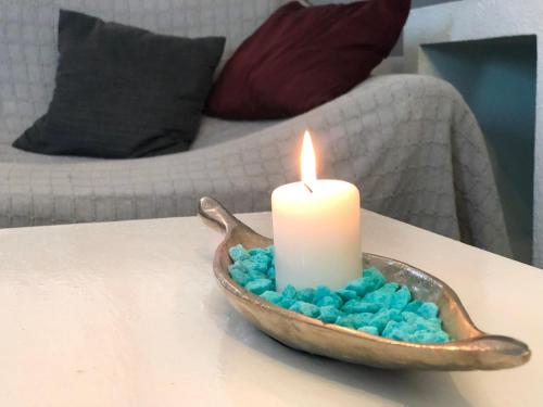 a candle sitting in a bowl with blue marshmallows at GreenTree House in Corralejo