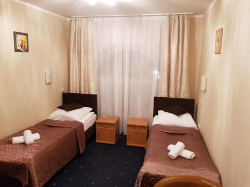 a hotel room with two beds and a window at Hotel Roko in Warsaw