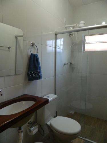 a bathroom with a shower and a toilet and a sink at Hospedaria Raízes da Serra in Serra do Cipo