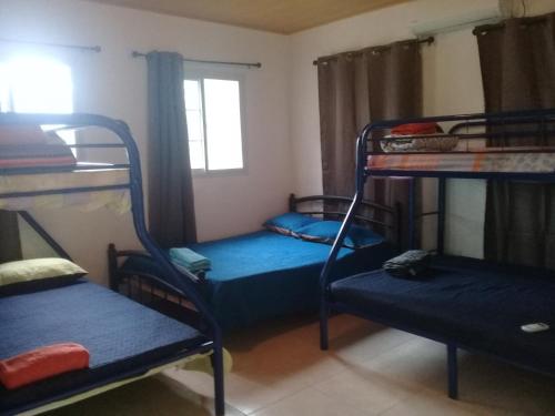 a room with three bunk beds and a window at Hotel Cabañas Casita La Ermita in San Carlos