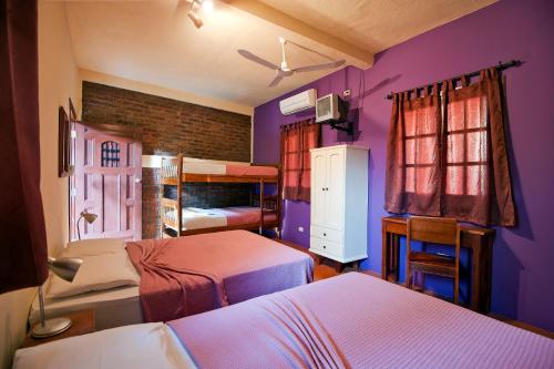 a bedroom with two beds and purple walls at Hotel La Pérgola in Granada