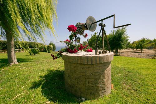 a statue of a cross and flowers in a brick barrel at Villa Russelia in Kalavárda