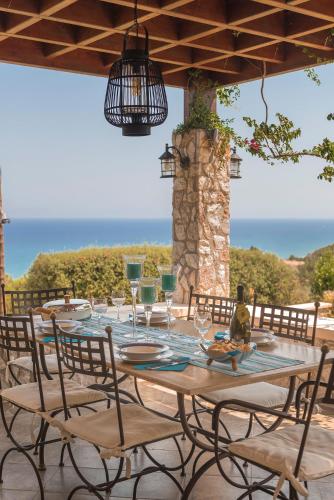 a table with glasses and chairs on a patio at Villa Russelia in Kalavárda