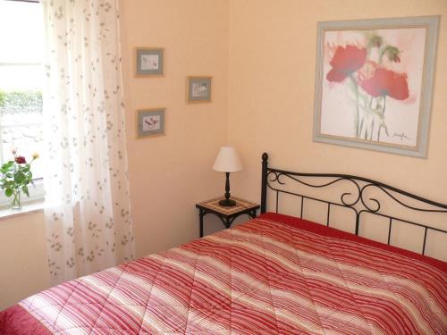 een slaapkamer met een bed met een rood dekbed en een raam bij Apartment Haus Antje in Sankt Peter-Ording