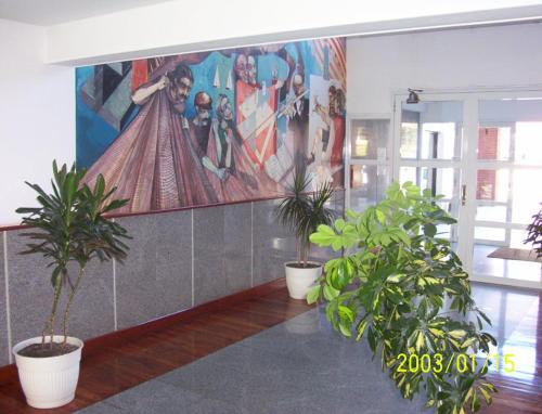 a large painting on the wall in a room with plants at Panoramico Playa Grande -Solo Familias in Mar del Plata
