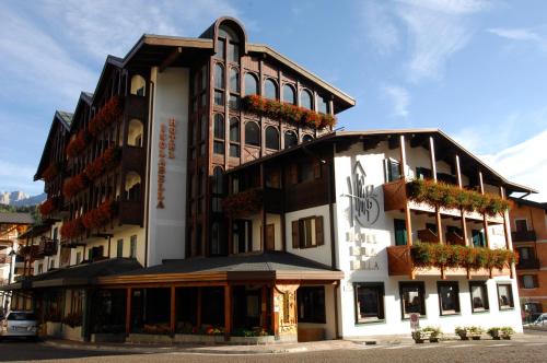 a large building with plants on the side of it at Hotel Isolabella Wellness in Fiera di Primiero