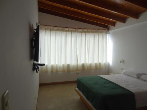 a bedroom with a bed and a large window at Akas Hotel Apartamentos in Canoas De Punta Sal