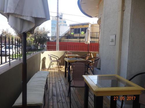 a patio with tables and chairs and an umbrella at Sentir Patagonia in Viña del Mar