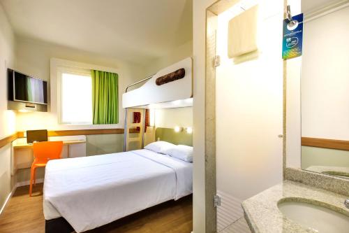 
a hotel room with a white bed and white walls at ibis budget Sao Jose do Rio Preto in Sao Jose do Rio Preto
