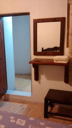 Ein Spiegel an der Wand neben einem Tisch in der Unterkunft Real Bonanza Posada in Guanajuato