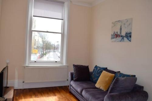 a living room with a couch and a window at Camden Apartment A/Apartment in London
