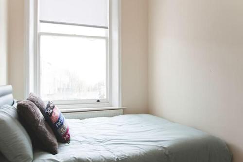a bed with two pillows in a room with a window at Camden Apartment A/Apartment in London