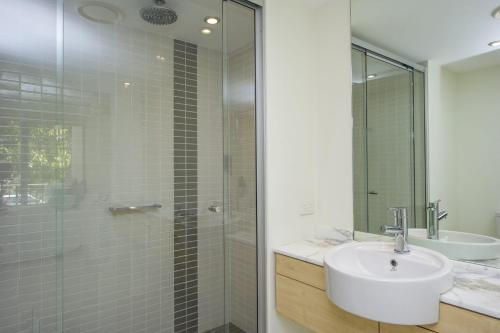 a bathroom with a sink and a glass shower at Blue on Blue Apartment 813 in Nelly Bay