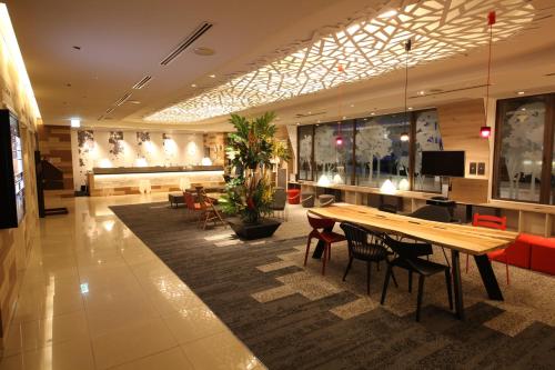 a lobby with a long wooden table and chairs at Kichijoji Tokyu REI Hotel in Musashino