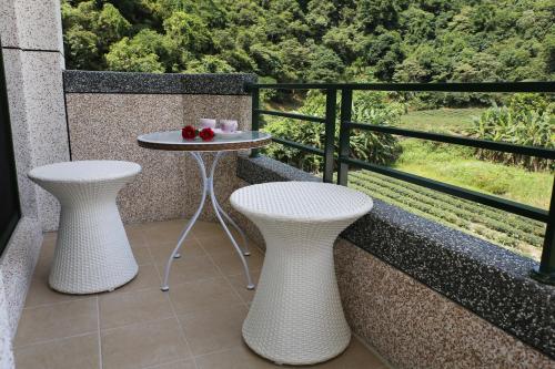a balcony with two stools and a table with strawberries on it at Teamilu Homestay in Datong