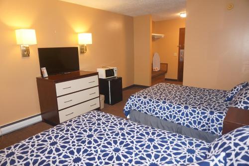 a hotel room with two beds and a flat screen tv at Bellevue Hotel and Suites in Bellevue