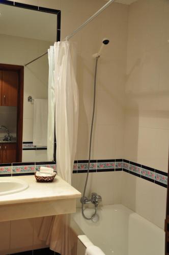 a bathroom with a tub and a sink and a shower at Vila Marta in Funchal