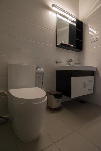 a white bathroom with a toilet and a sink at Sea View Luxury Apartment, Fully Furnished, 2 Bedrooms, 2 Bathrooms in Mount Lavinia
