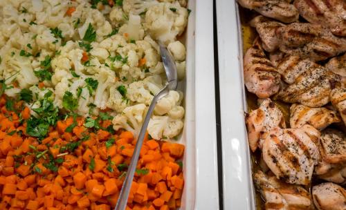a tray of food with carrots cauliflower and other vegetables at Acharavi Beach Hotel in Acharavi