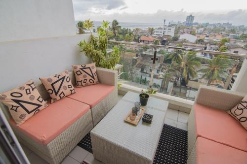 a balcony with a couch and a view of the city at Sea View Luxury Apartment, Fully Furnished, 2 Bedrooms, 2 Bathrooms in Mount Lavinia