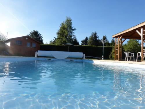 - une grande piscine dans une cour avec une maison dans l'établissement La Campagnarde, à Saint-Just-en-Chevalet