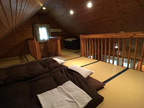 a room with a bed in a wooden cabin at Log Cottage Tomato in Hakuba