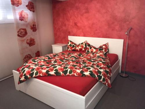 ein Schlafzimmer mit einem Bett mit einer roten Wand in der Unterkunft Casa Christina in Orschweier