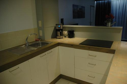 a kitchen with a sink and a counter top at Studio De Zunneblomme in Middelkerke