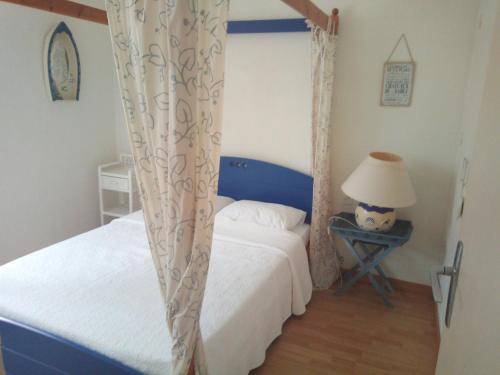 ナルボンヌ・プラージュにあるMaison du Portのベッドルーム1室(ベッド2台、ランプ付きテーブル付)