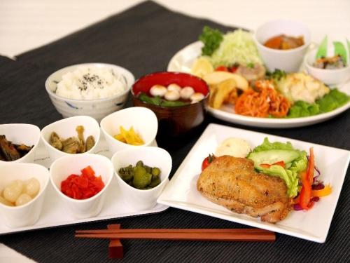 a table with plates of food and bowls of food at Value The Hotel Sendai Natori in Natori
