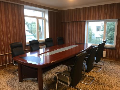 a conference room with a large wooden table and chairs at Platinum Hotel Ulaanbaatar in Ulaanbaatar