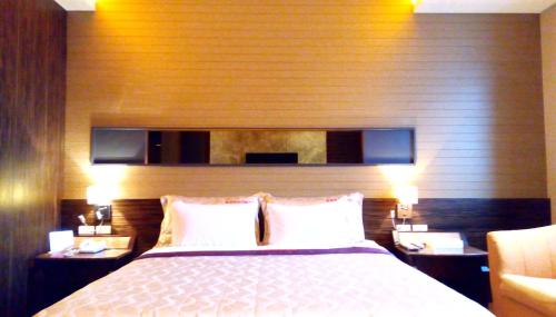 a bedroom with a large bed with two night stands at 華倫汽車旅館 in Erlin