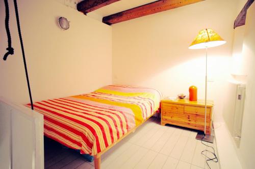 Dormitorio pequeño con cama y lámpara en Tartana by KlabHouse, en Grado