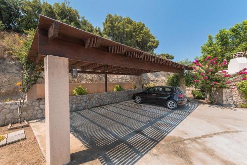 a car parked under a metal parking lot at Villa Russelia in Kalavárda