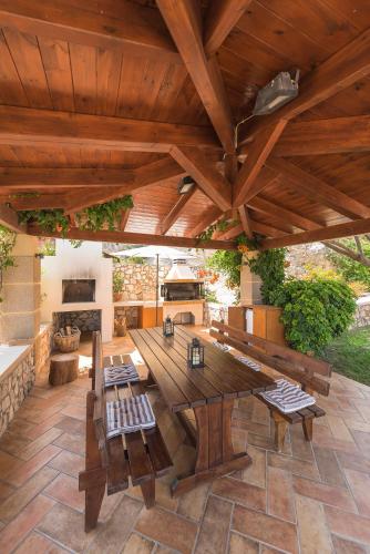 an outdoor patio with a wooden table and benches at Villa Russelia in Kalavárda