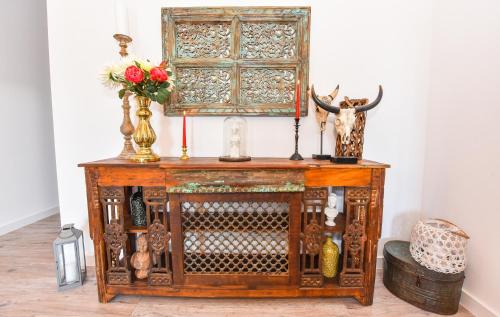 an old wooden cabinet with vases and flowers on it at Parliament & River View Apartments in Bucharest