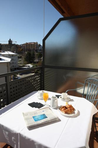a white table with a plate of food on a balcony at Hotel & Spa Real Jaca in Jaca