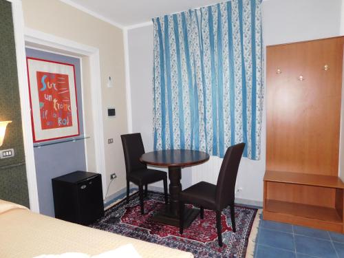 a room with a table and two chairs and a bed at Hotel Blumentag in Paola