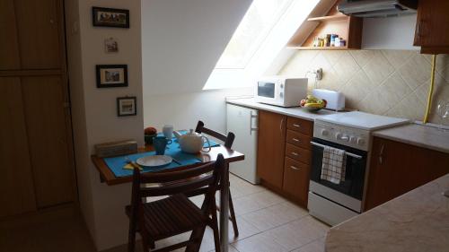 a small kitchen with a table and a microwave at Éger Apartman in Eger