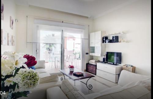 salon z białą kanapą i stołem w obiekcie Apartamento familiar con JARDIN y TERRAZA Privada w mieście La Alcaidesa