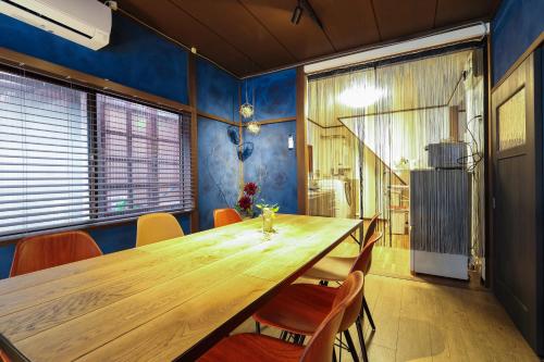uma sala de jantar com uma mesa de madeira e cadeiras em Copain Kurumi em Kanazawa