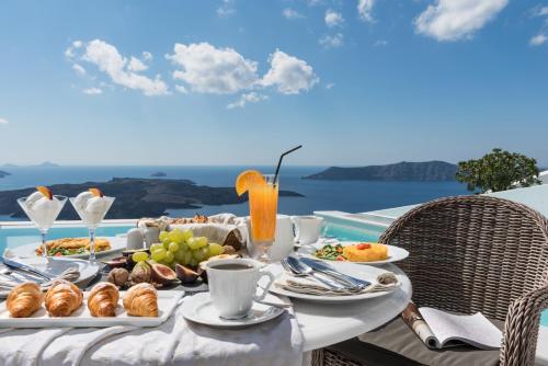 a table with food on it with a view of the ocean at Anteliz Suites in Fira