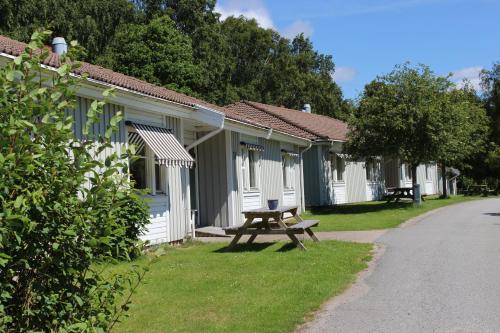 a row of cottages with a picnic table in the grass at Nordiska Folkhögskolan Bed and Breakfast in Kungälv