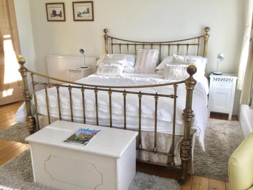 a bedroom with a bed with white sheets and a table at Cliftonville House in Whitstable