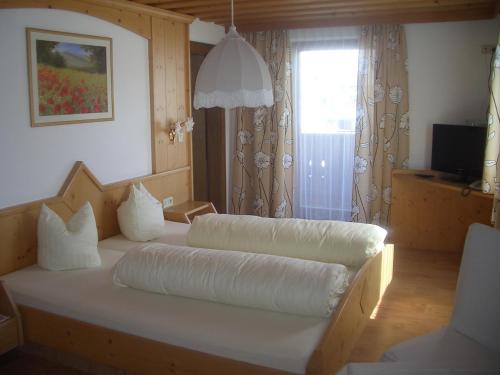 a bedroom with a large bed with white pillows at Aparthotel Garni am Johannesbrunnen in Fiss