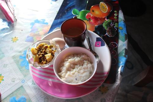 a plate of food with a bowl of rice and snacks at Patlekhet Community Homestay in Patlekhet