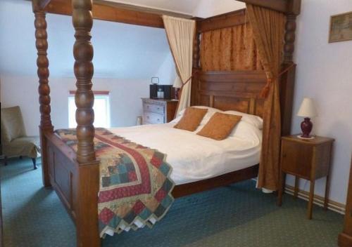 a bedroom with a four poster bed with a canopy at Dolifor in Llanwrthwl